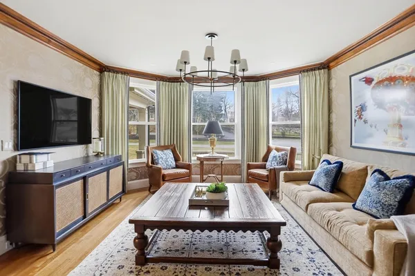 a living room with furniture a flat screen tv and a large window