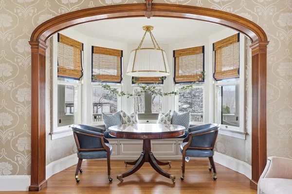 a dining room with furniture a chandelier and wooden floor