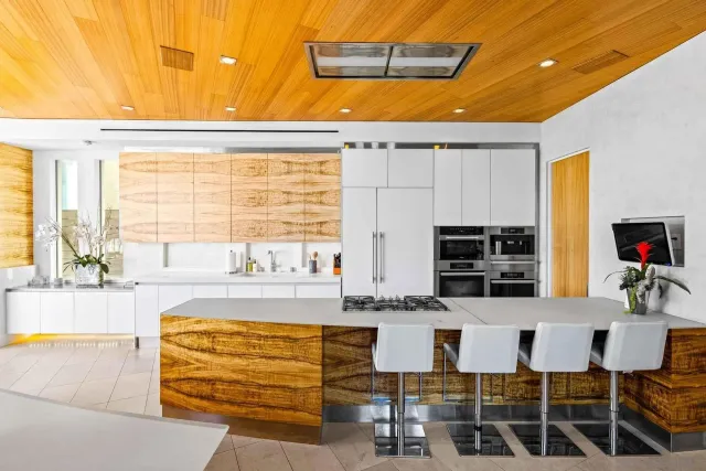 a kitchen with granite countertop a stove and white cabinets