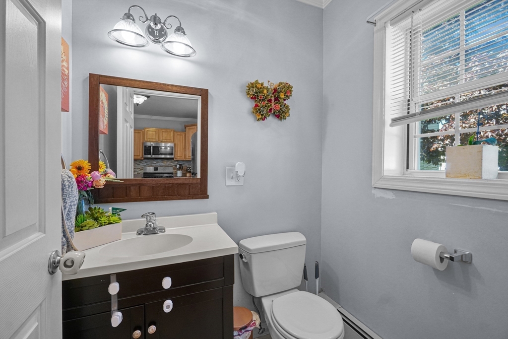 249 Baird Street Fall River, MA 02721 - Photo 10 of 23 a bathroom with a toilet a sink and mirror