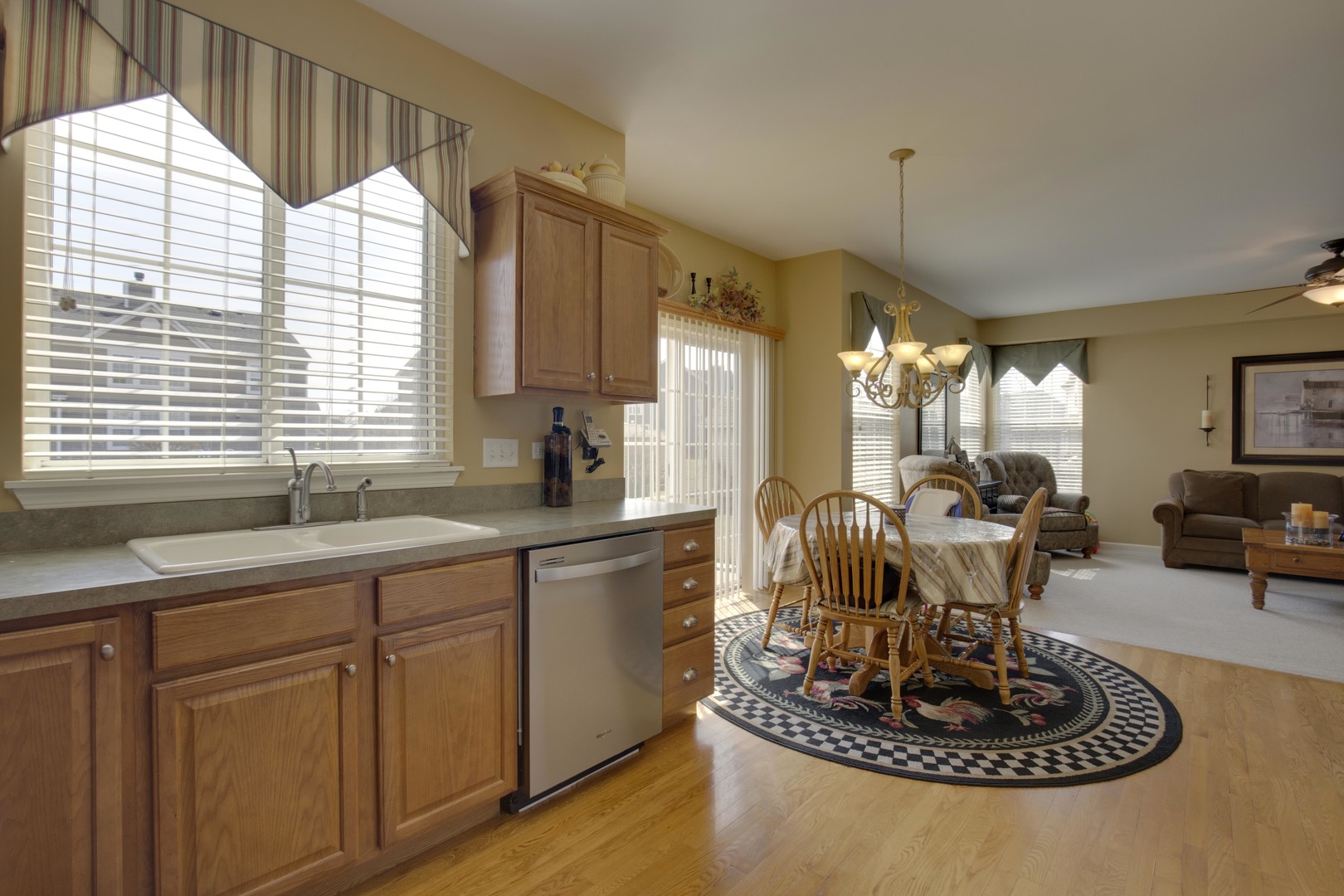 9610 Newton Road Huntley, IL 60142 - Photo 10 of 23 a kitchen with kitchen island granite countertop a sink cabinets and a large window