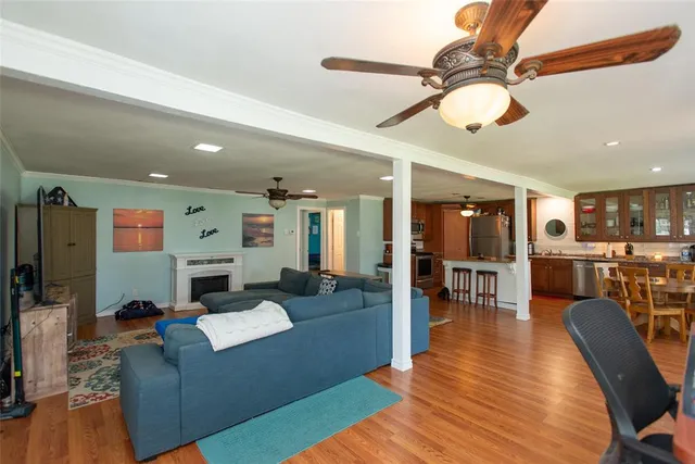a living room with furniture kitchen view and a wooden floor
