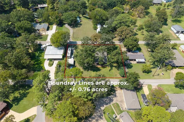 an aerial view of a house with a yard and lake view