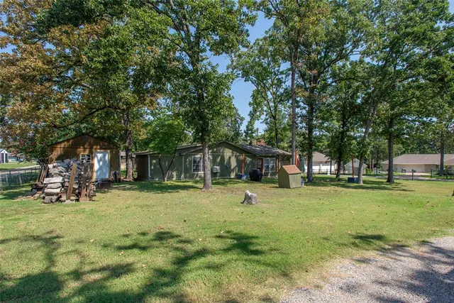 a view of a trees in a yard with a house