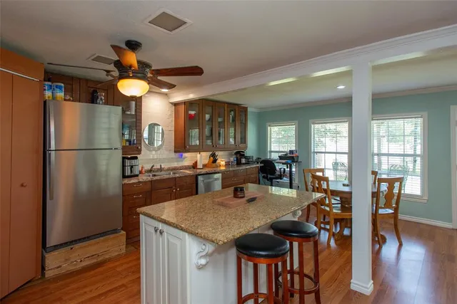 a kitchen view with stainless steel appliances granite countertop furniture wooden floor and a refrigerator