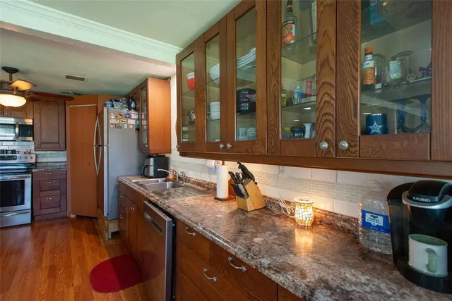 a kitchen with stainless steel appliances granite countertop a sink and a wooden cabinets