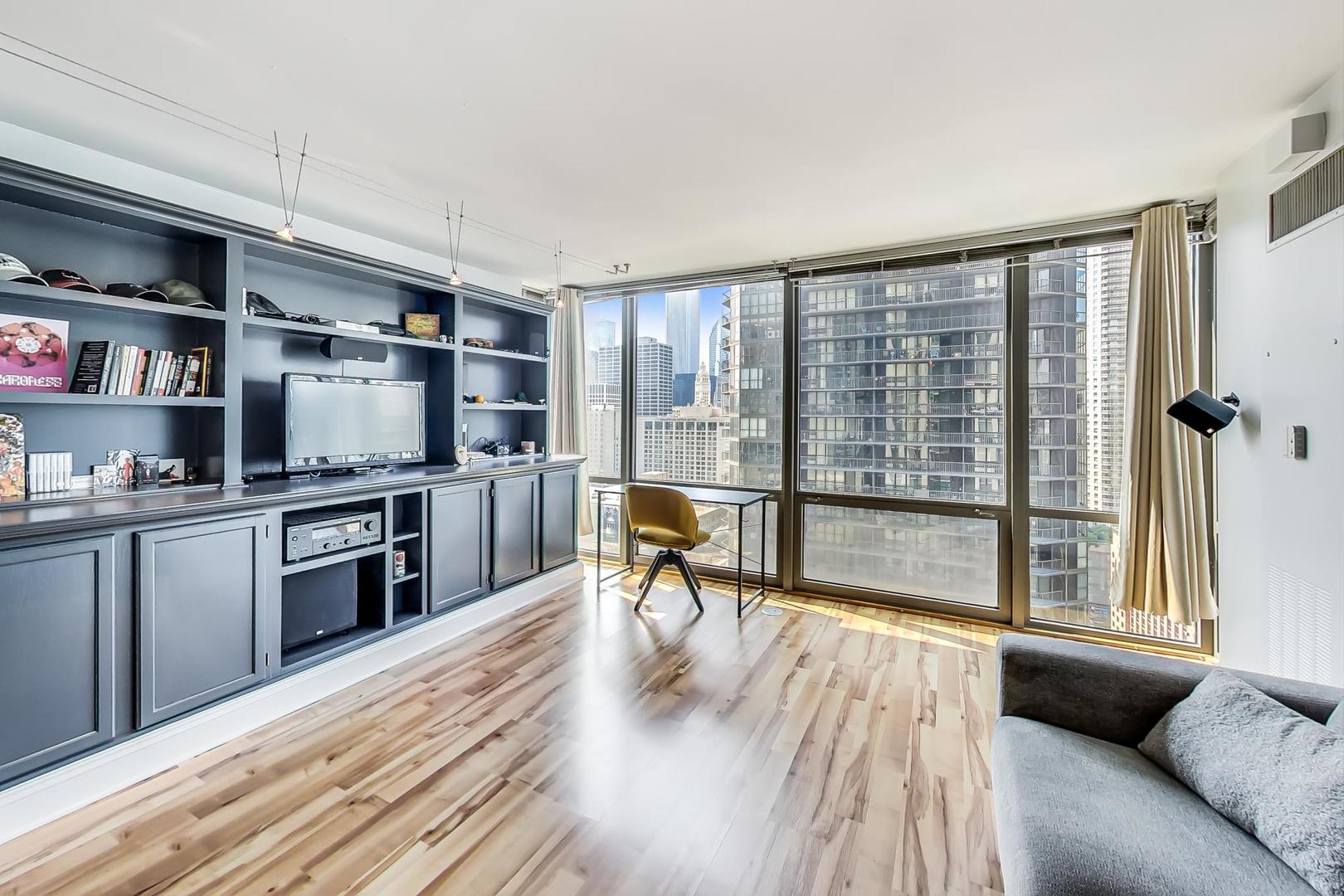 2 East Erie Street, Unit 2204 Chicago, IL 60611 - Photo 5 of 19 a living room with stainless steel appliances furniture a flat screen tv and a floor to ceiling window