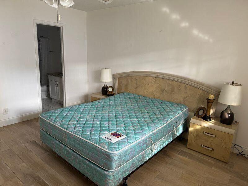 5401 Northwest 2nd Avenue, Unit 219 Boca Raton, FL 33487 - Photo 9 of 15 a bedroom with bed and a night stand