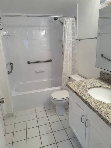 a bathroom with a granite countertop sink a toilet and shower