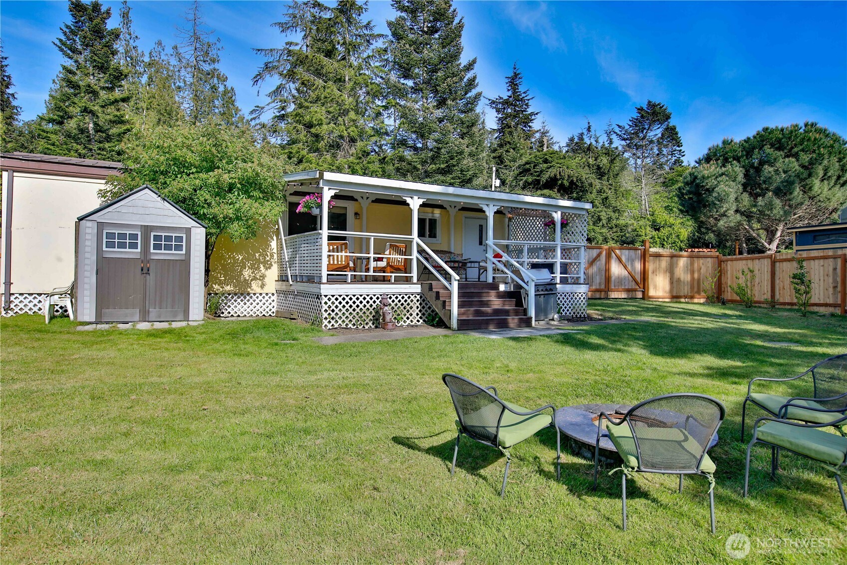 3276 East Harbor Road Langley, WA 98260 - Photo 32 of 37 a view of a backyard with table and chairs potted plants and large tree