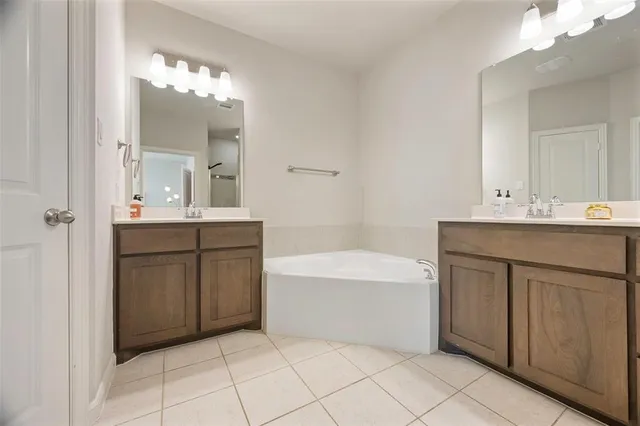 a bathroom with a sink vanity tub and a mirror