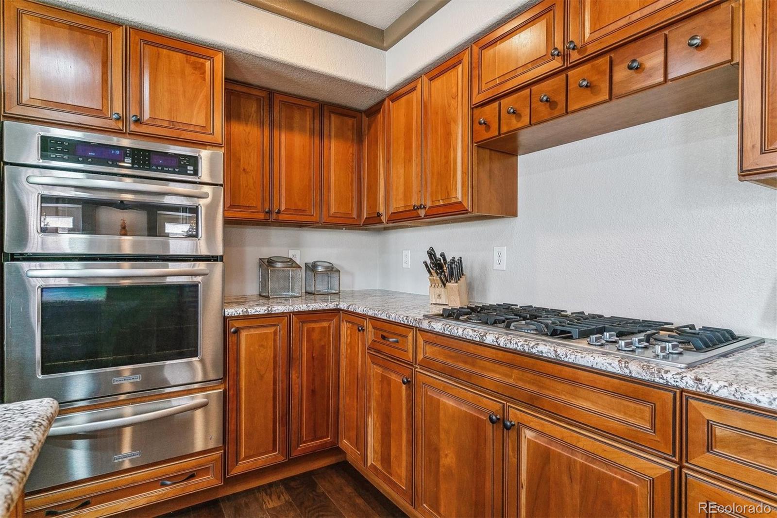 9109 South Ironwood Way Highlands Ranch, CO 80129 - Photo 12 of 49 a kitchen with stainless steel appliances granite countertop a stove and cabinets