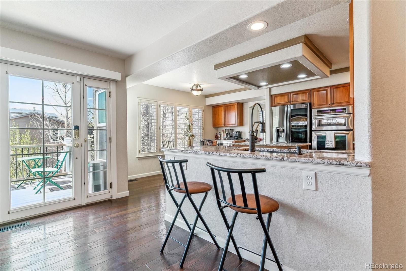 9109 South Ironwood Way Highlands Ranch, CO 80129 - Photo 15 of 49 a dining room with wooden floor and a floor to ceiling window