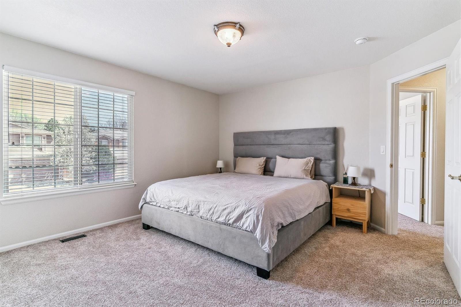 9109 South Ironwood Way Highlands Ranch, CO 80129 - Photo 32 of 49 a bed sitting in a bedroom next to a window