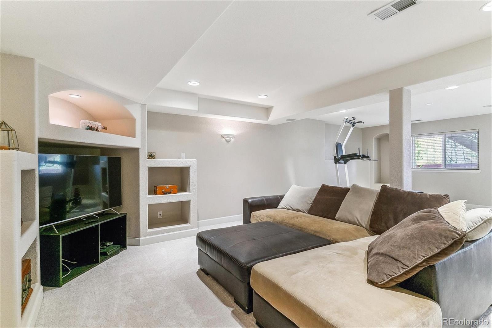 9109 South Ironwood Way Highlands Ranch, CO 80129 - Photo 40 of 49 a living room with furniture and a flat screen tv