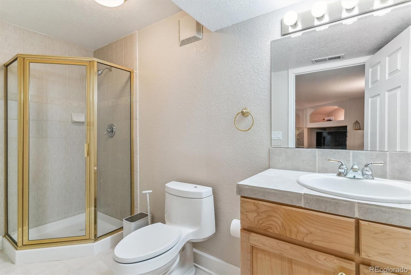 9109 South Ironwood Way Highlands Ranch, CO 80129 - Photo 41 of 49 a bathroom with a sink a toilet and shower