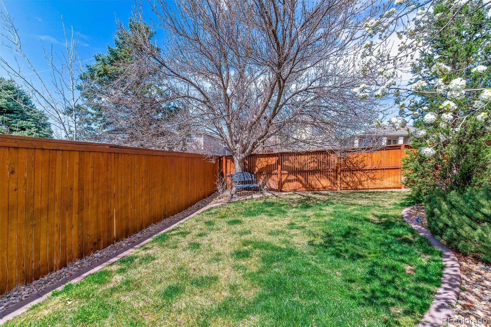 9109 South Ironwood Way Highlands Ranch, CO 80129 - Photo 42 of 49 a backyard of a house with lots of green space and wooden fence
