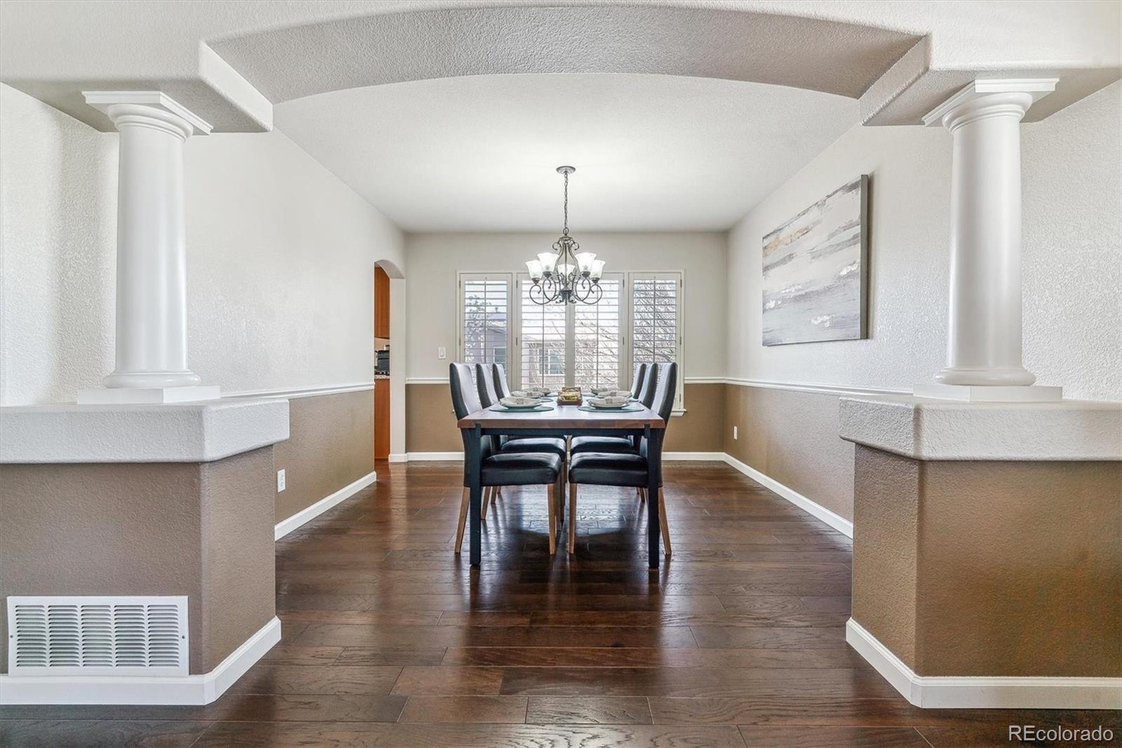 9109 South Ironwood Way Highlands Ranch, CO 80129 - Photo 8 of 49 a dining room with wooden floor a chandelier a wooden table and chairs