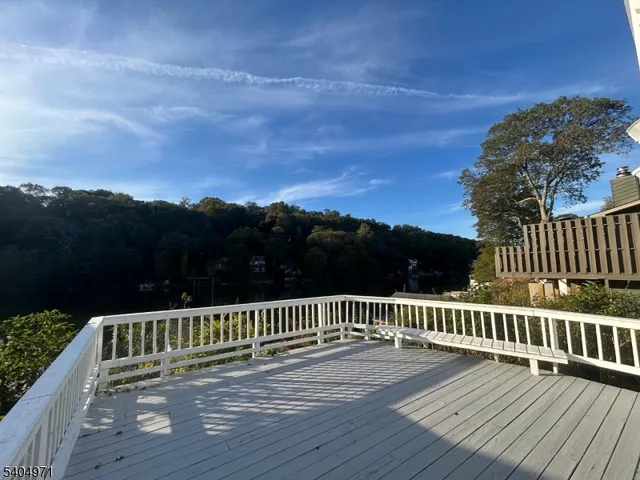 a view of deck with wooden fence and trees