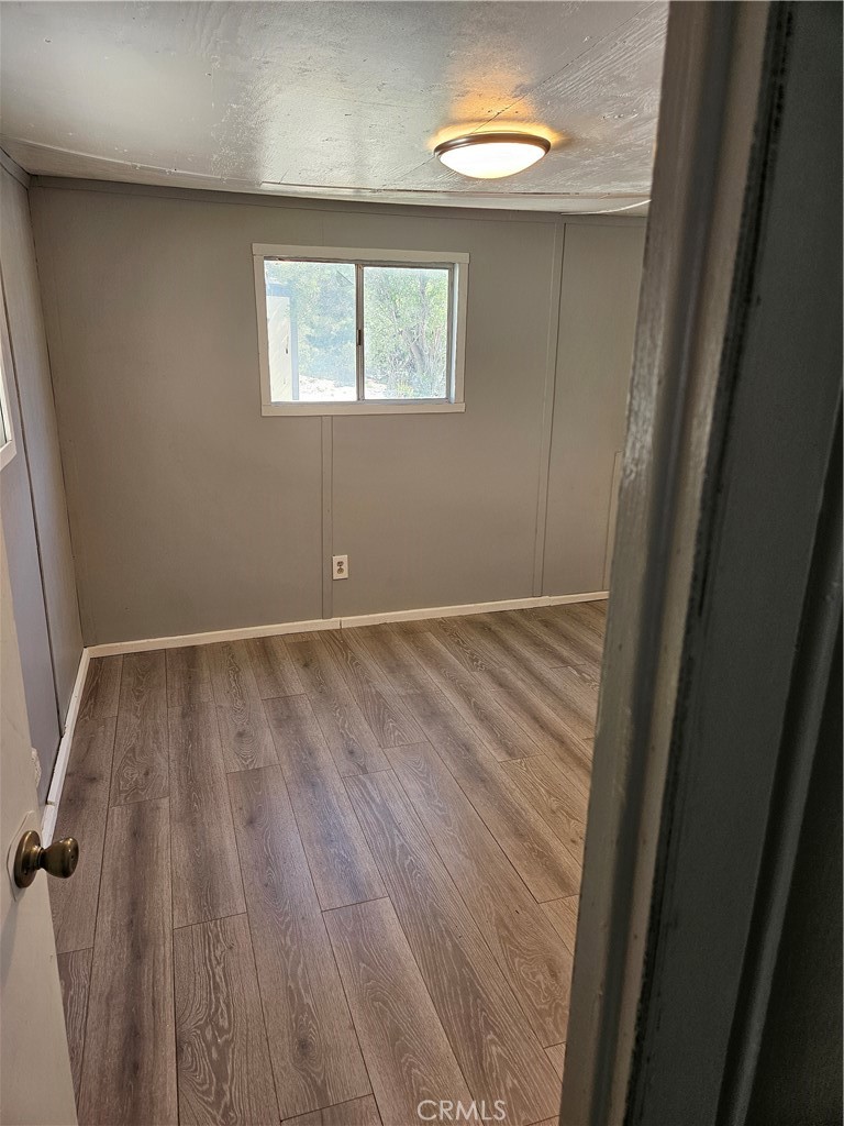 2801 Johnson Road Frazier Park, CA 93225 - Photo 6 of 6 an empty room with wooden floor and windows