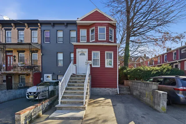 a front view of a house with stairs and a garden