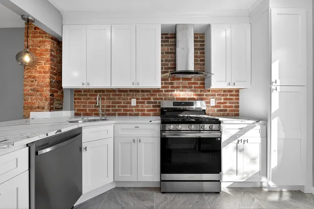 a kitchen with granite countertop white cabinets stainless steel appliances and sink