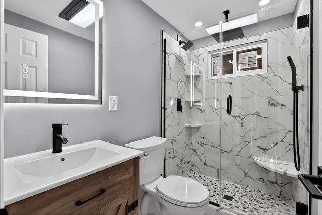 a bathroom with a sink toilet a mirror and shower