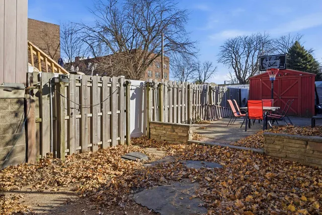a view of backyard with wooden fence and large trees