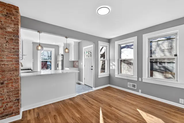 a view of a bedroom with wooden floor and a window