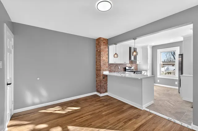 a kitchen with granite countertop a sink cabinets and wooden floor