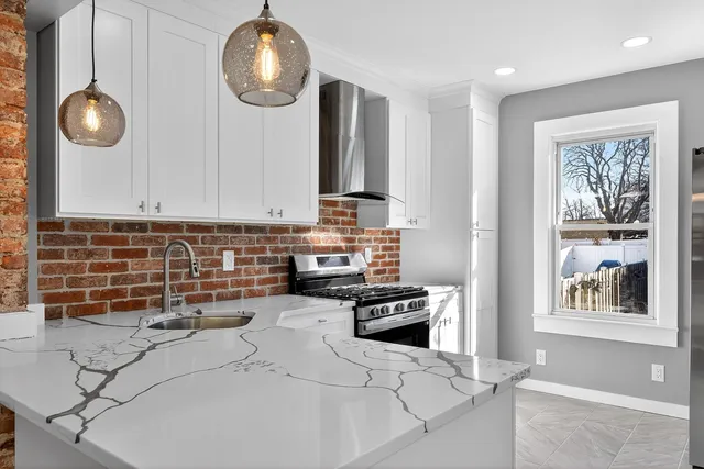 a kitchen with stainless steel appliances a stove a sink and a microwave