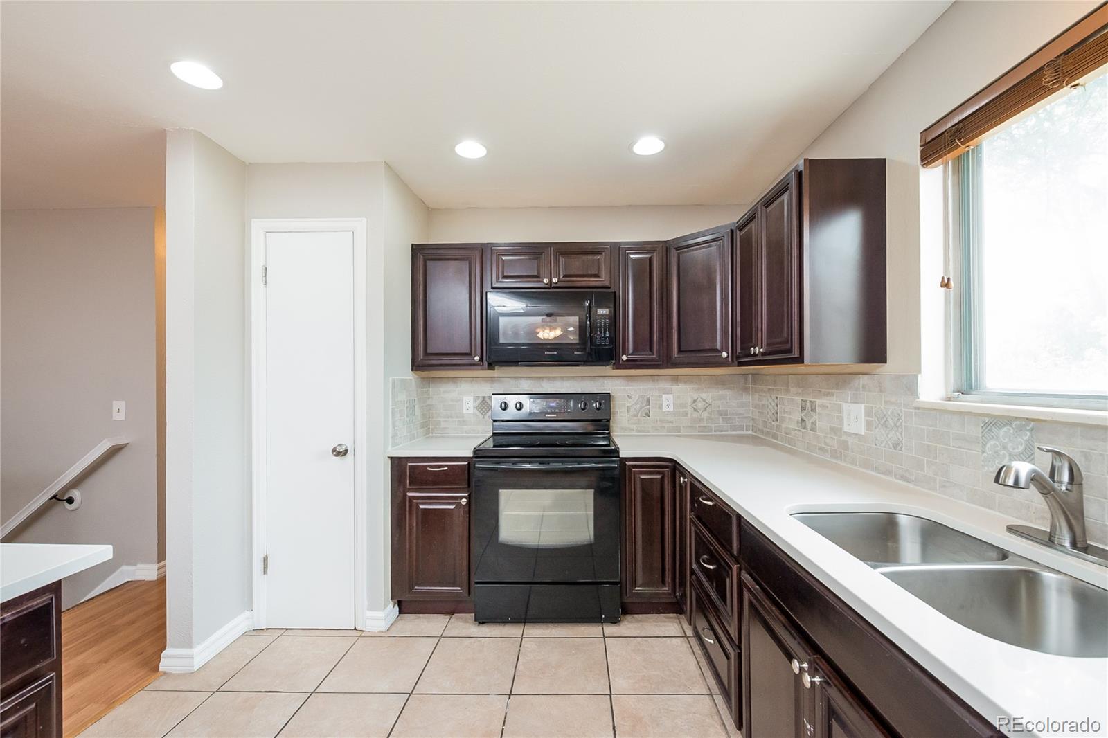 11103 Eudora Circle Thornton, CO 80233 - Photo 5 of 17 a kitchen with a sink and a stove top oven