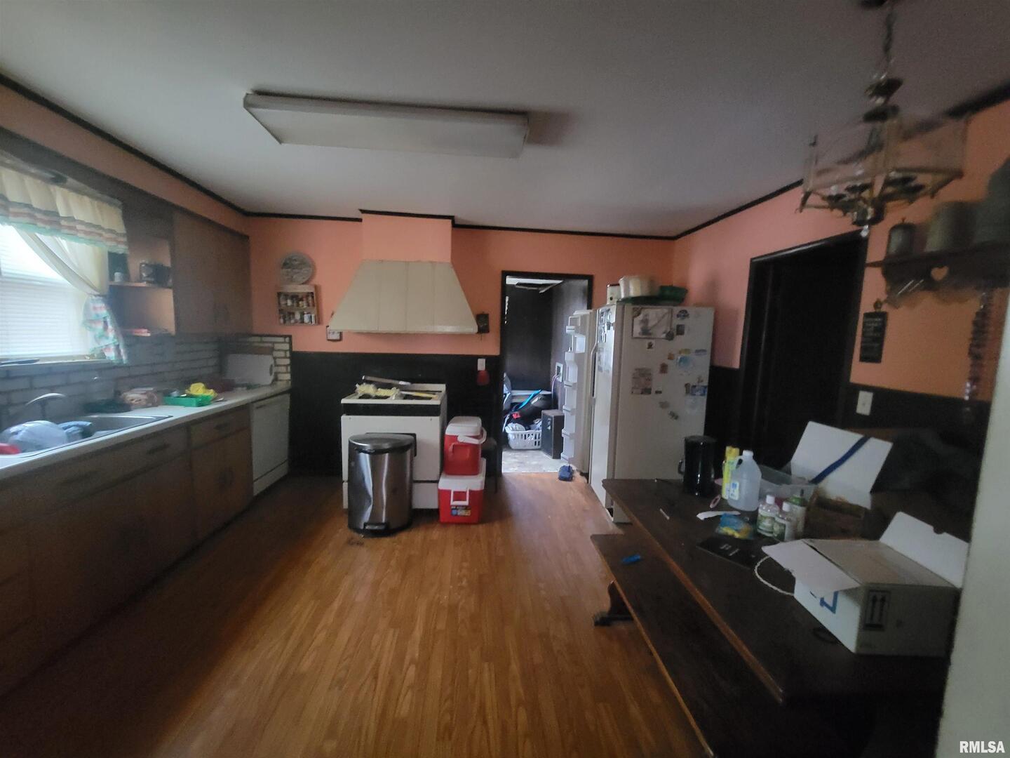 905 West Monroe Street Herrin, IL 62948 - Photo 10 of 14 a kitchen with granite countertop a stove dining table chairs and a refrigerator