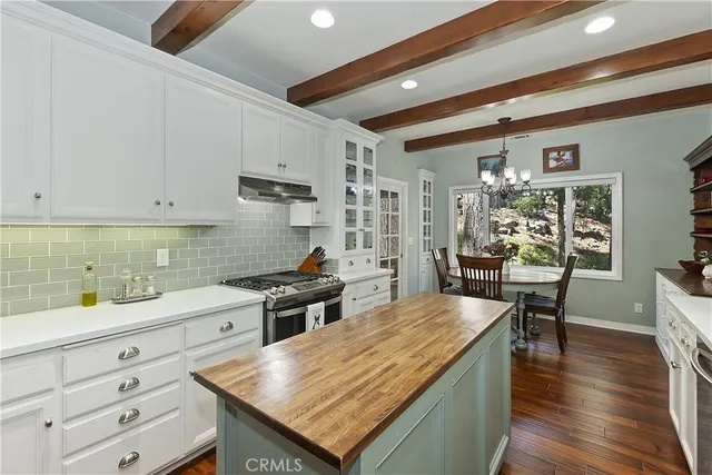 a kitchen with a stove a refrigerator and wooden floor