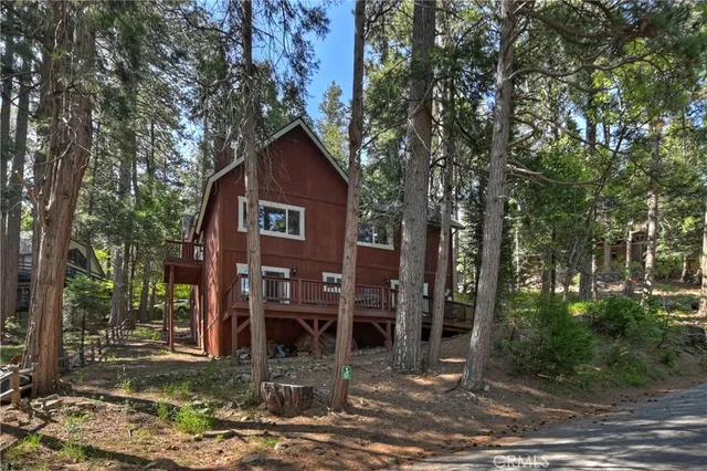 a view of a house with a yard and large trees