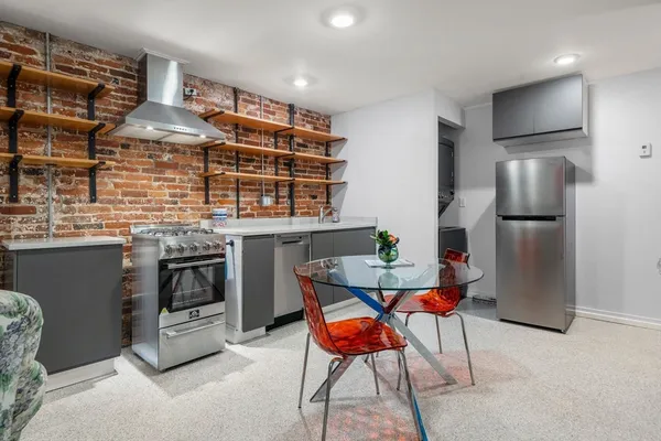 a kitchen with stainless steel appliances kitchen island granite countertop a refrigerator and a stove top oven