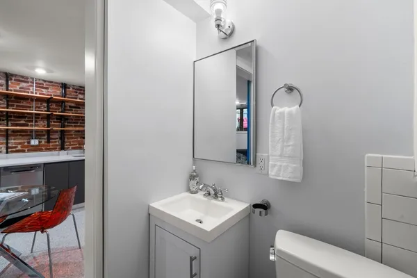 a bathroom with a toilet sink and mirror