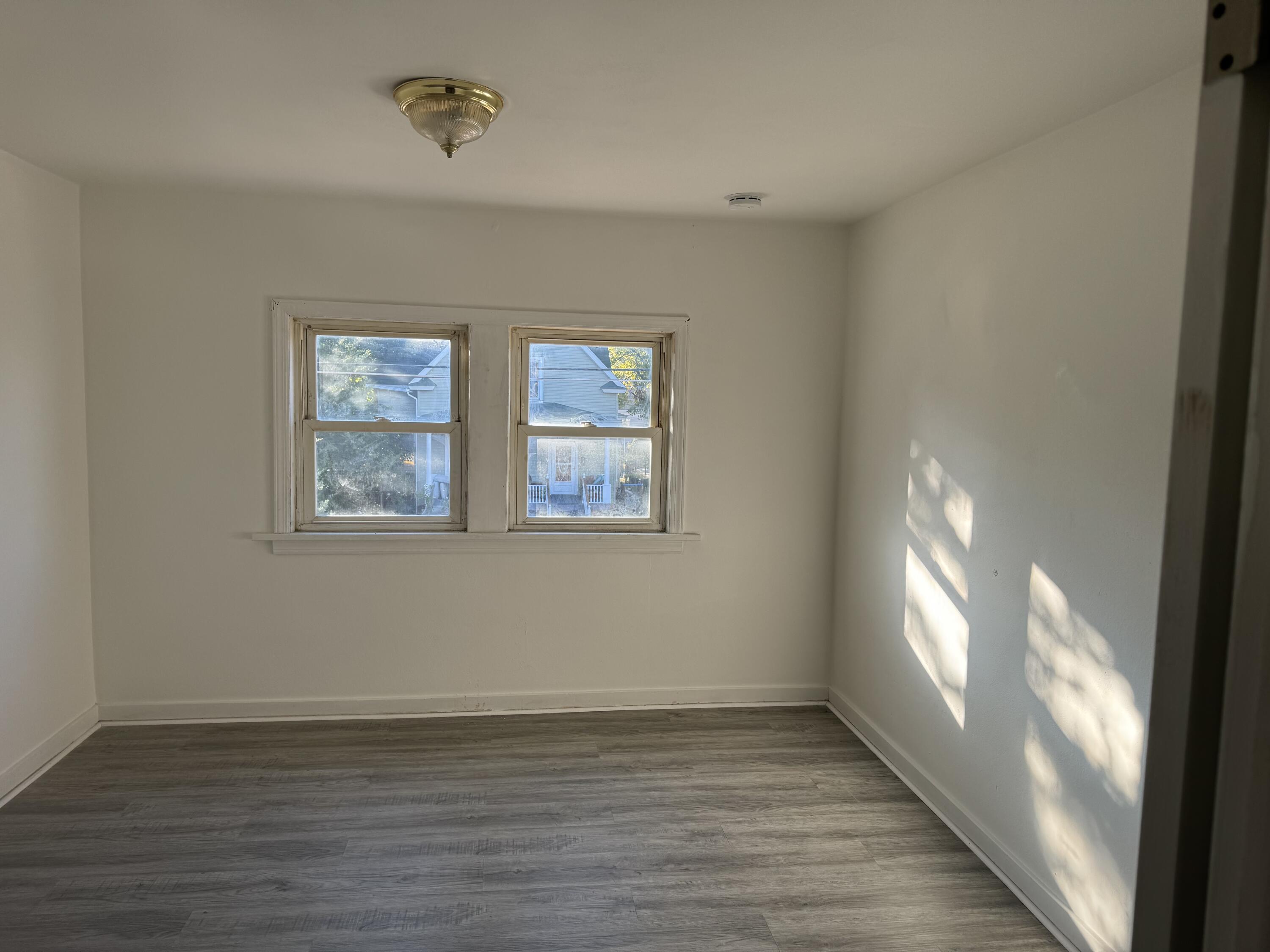 217 West Ripley Street Michigan City, IN 46360 - Photo 23 of 28 an empty room with wooden floor and windows