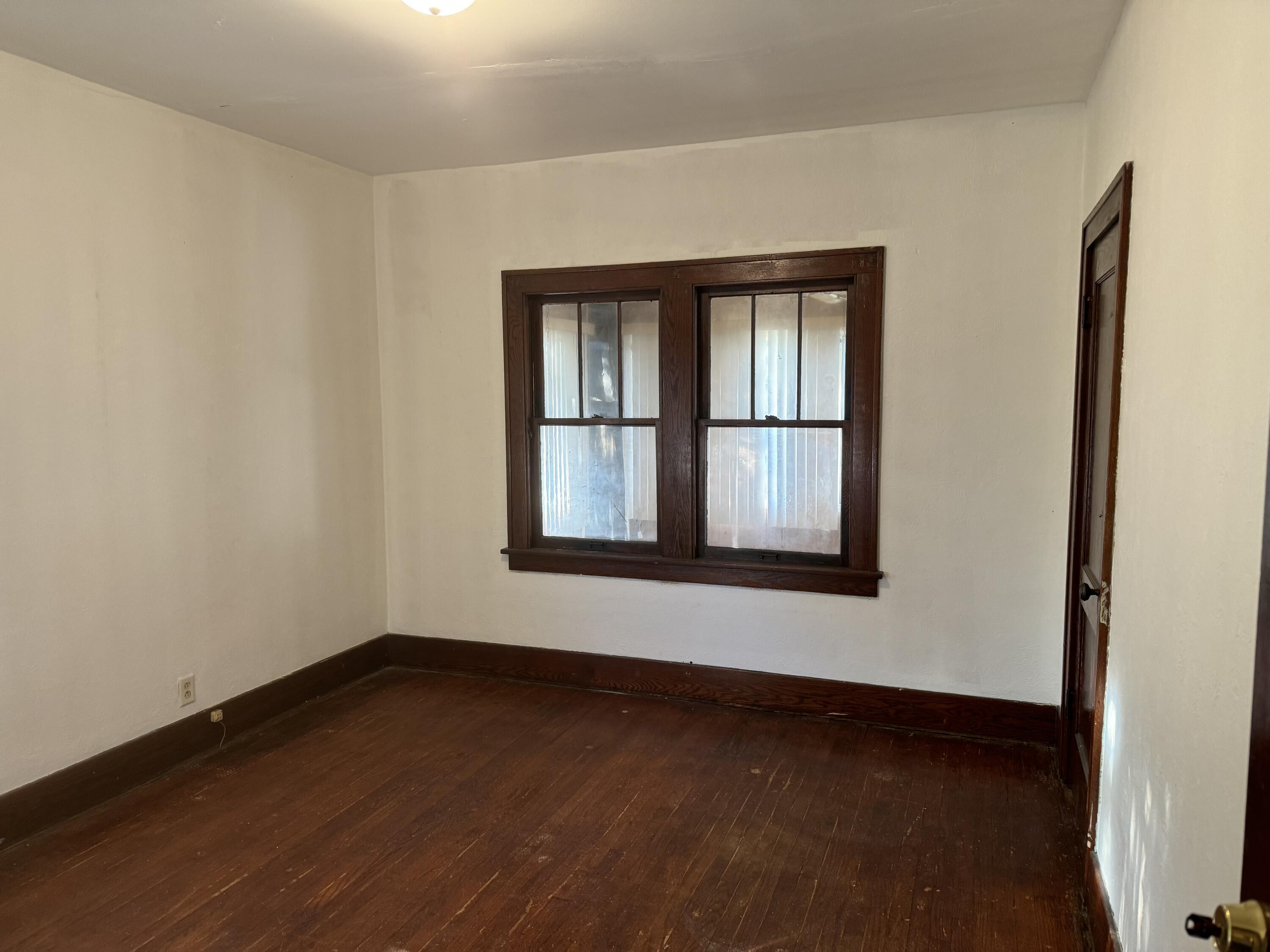 217 West Ripley Street Michigan City, IN 46360 - Photo 7 of 28 an empty room with wooden floor and windows