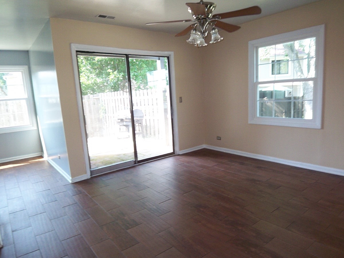 1925 Georgetown Lane Hoffman Estates, IL 60169 - Photo 12 of 29 an empty room with wooden floor fan and windows