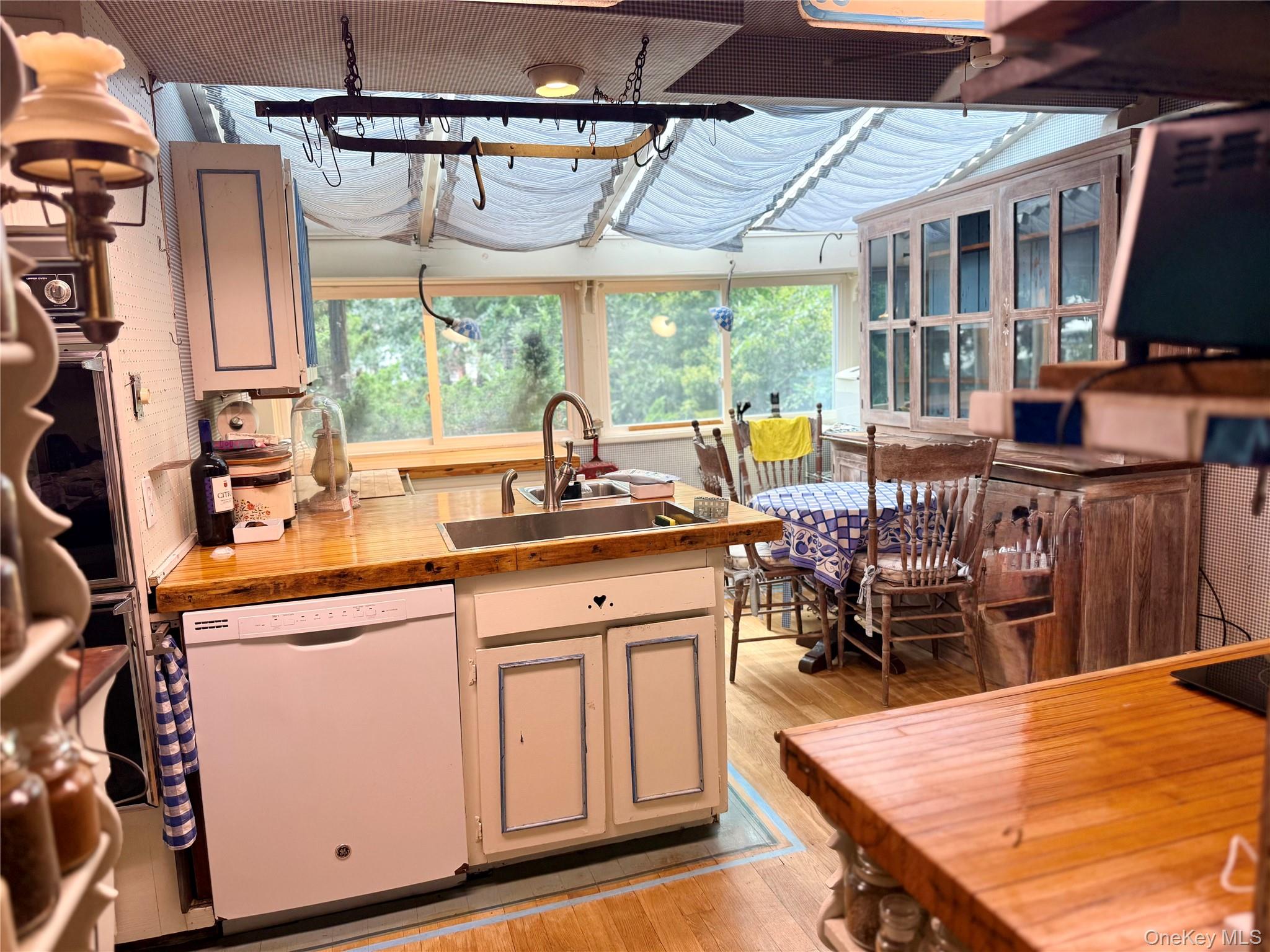 335 Arthur Street Freeport, NY 11520 - Photo 5 of 17 a kitchen with stainless steel appliances granite countertop a stove a sink dishwasher and microwave with wooden floor