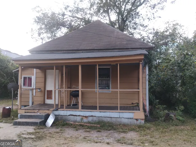 a front view of a house with a tree