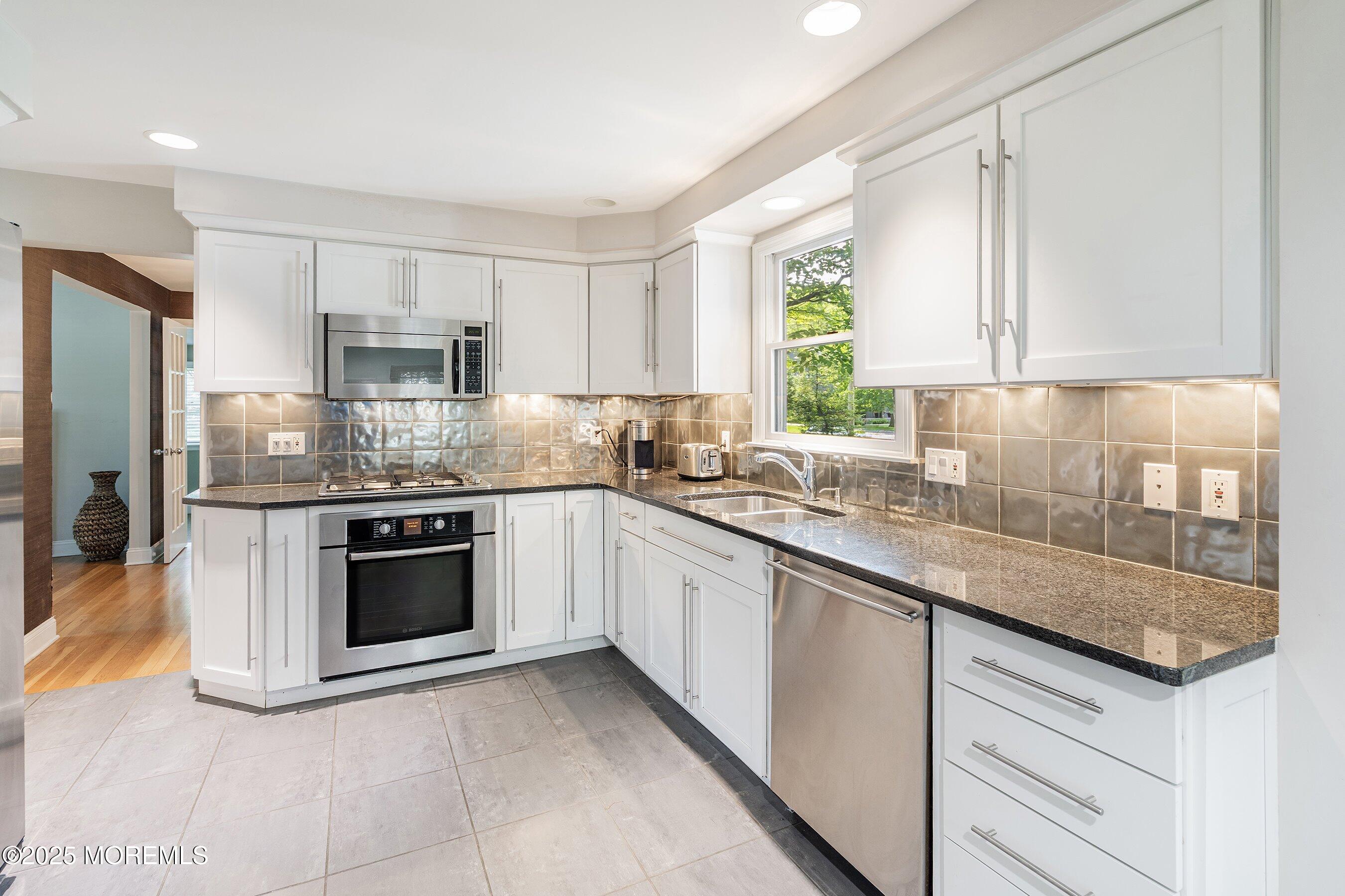76 Ridge Road Fair Haven, NJ 07704 - Photo 7 of 22 a kitchen with kitchen island granite countertop a stove sink and microwave