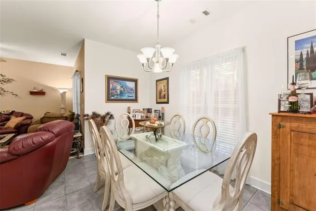 an aerial view of a house with a yard lake and trees all around