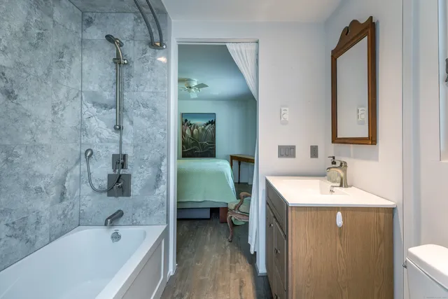 a bathroom with a tub sink and mirror