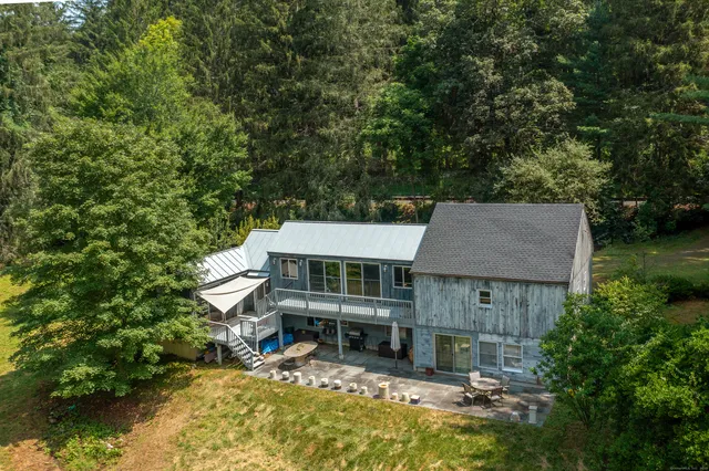 an aerial view of a house with swimming pool and large trees