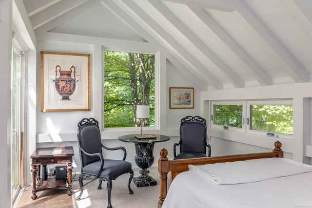 a bedroom with a bed and a large window