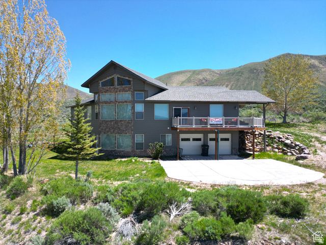 1940 East Shore Road St. Charles, ID 83272 - Photo 2 of 64 View of front facade with a mountain view, an attached garage, a patio area, a balcony, and driveway