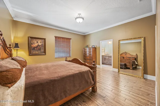 a bedroom with a large bed and a chandelier