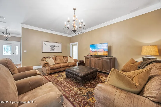 a living room with furniture and a chandelier